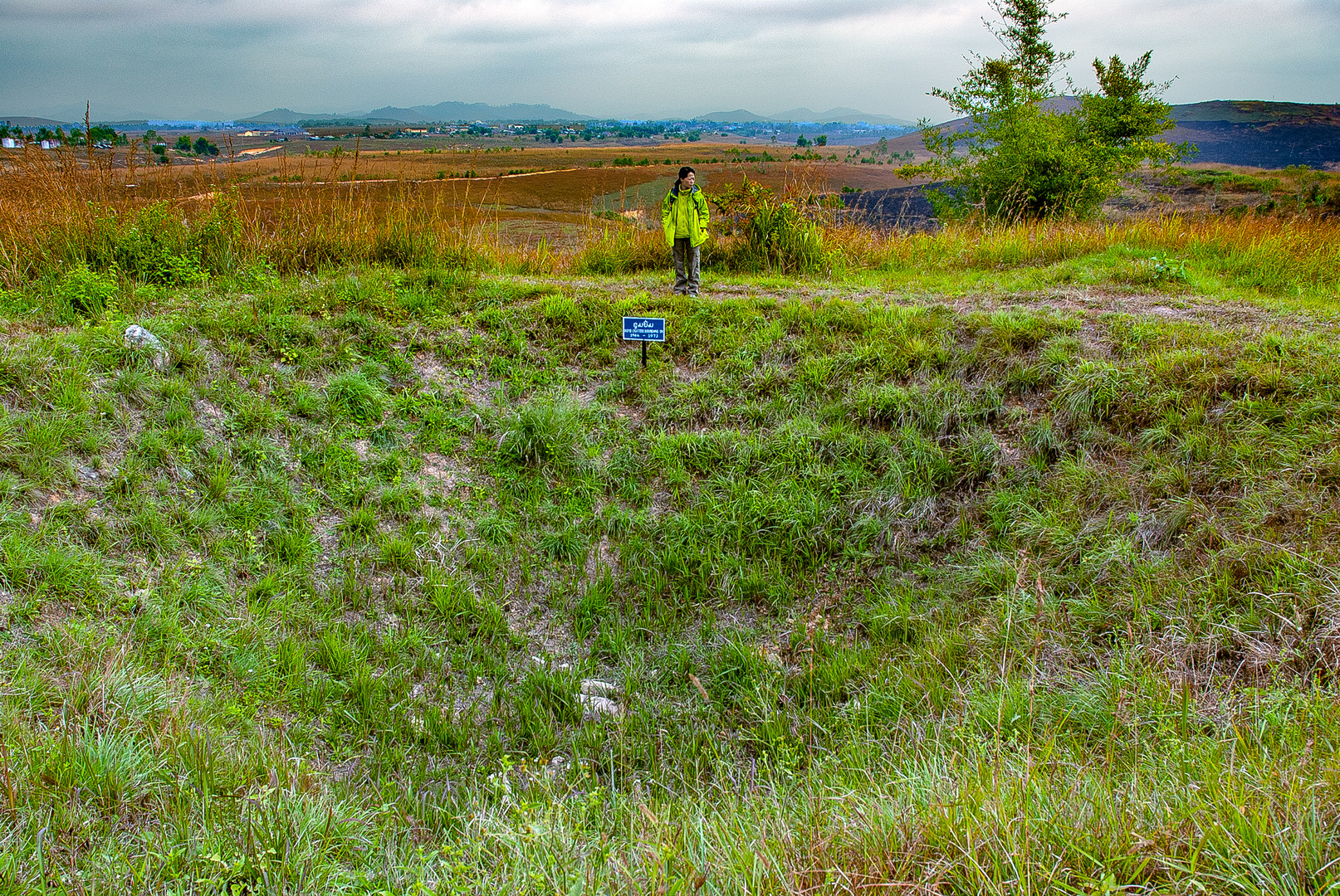 Man at the edge of a bomb crater