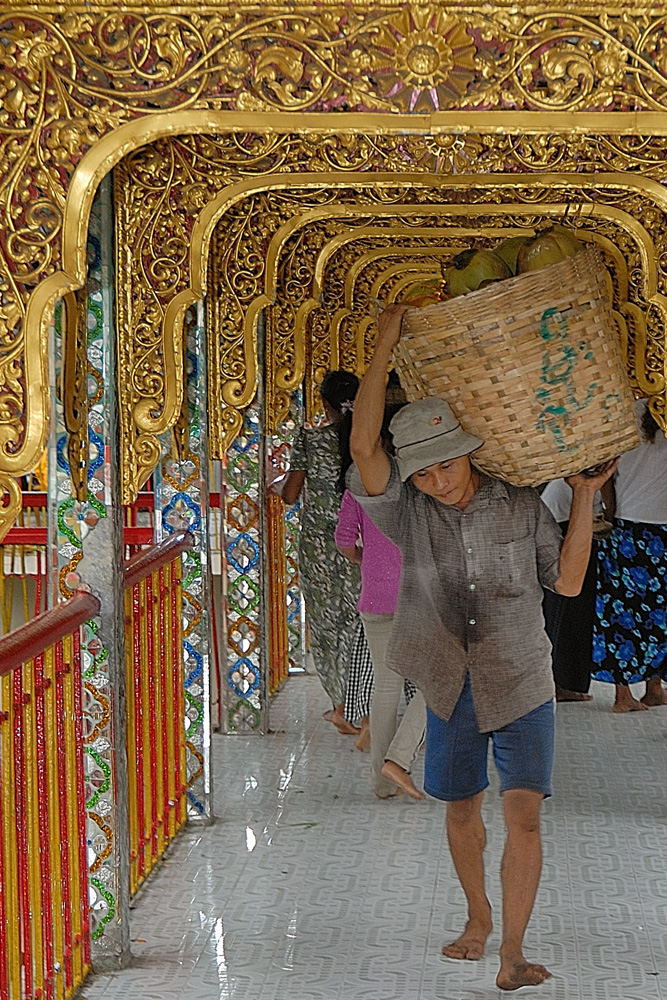 Man carrying a basket full of coco in the Botataung Pagoda