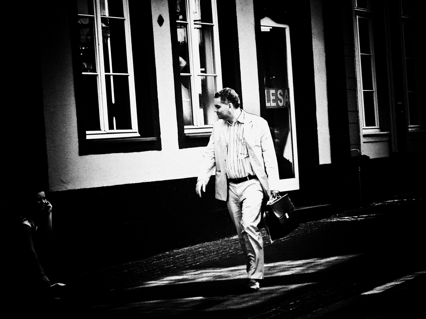 man with a white suit and a black bag looking for a young teen