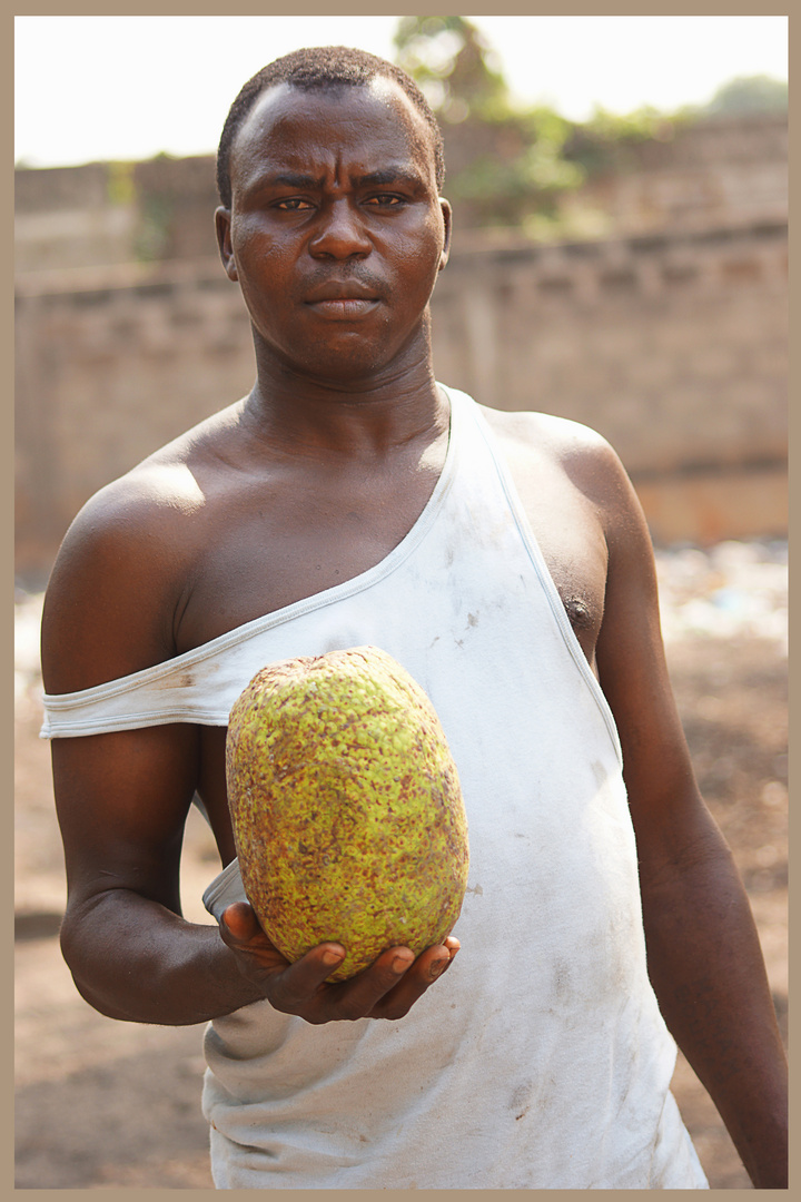 Mann mit Yamfrucht