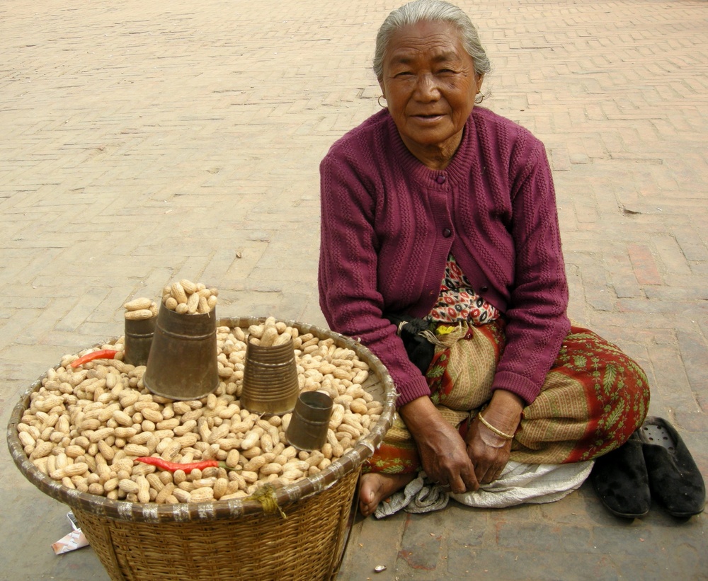 Marktfrau verkauft Erdnüsse in Kathmandu