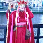 Maskierte Frau mit rotem Kostüm und Hahn.
