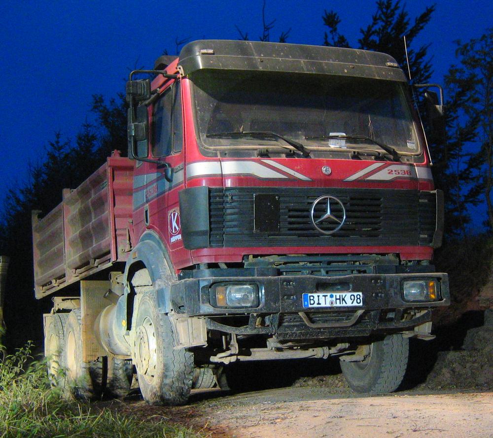 MB SK 2538 in der späten Abenddämmerung beleuchtet von einer Straßenlaterne und Autoscheinwerfern.