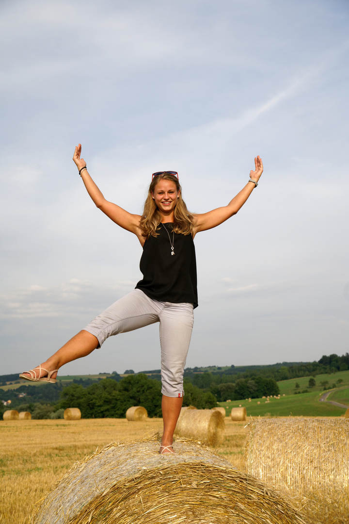 Melanie balanciert auf Strohballen