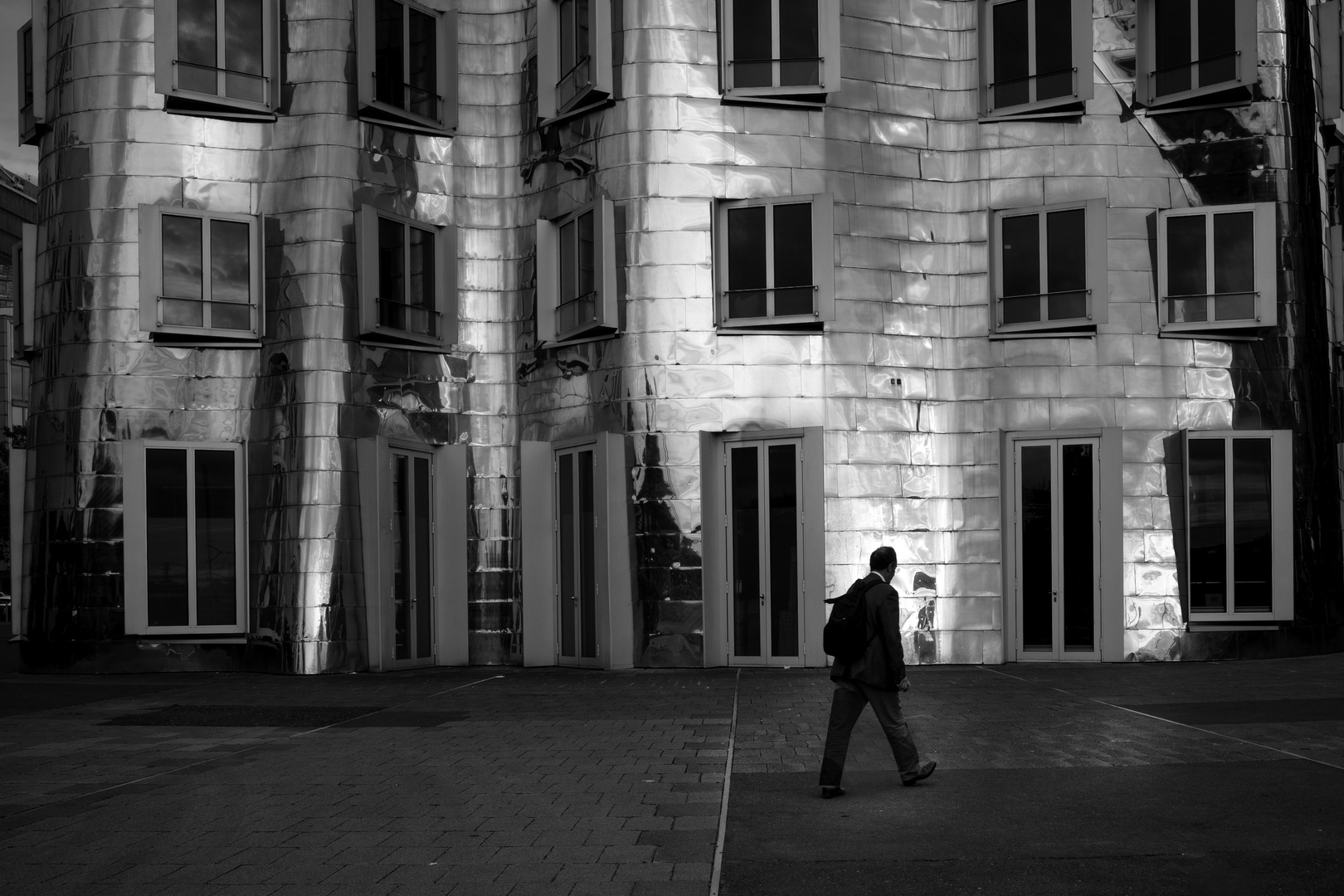 Mensch vor dem Gehry-Gebäude in Düsseldorf