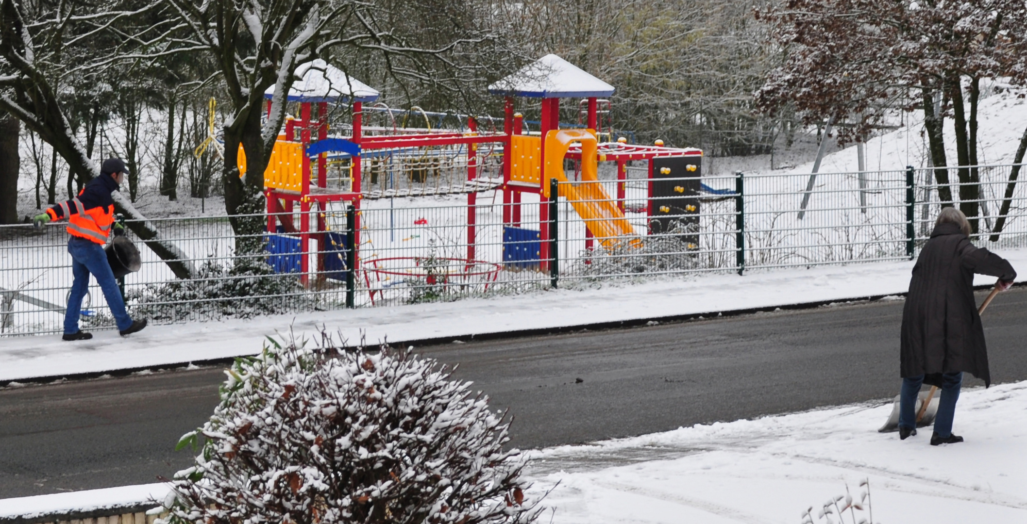 Menschen beim Schnee räumen