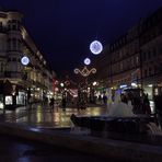 Menschen in einer vorweihnachtlich beleuchteten nächtlichen Stadt