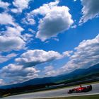 Michael Schumacher and mountains beneath a blue cloudy sky