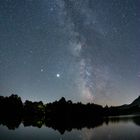 Milchstraße spiegelt sich in kleinem See im Chiemgau. 