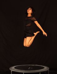 Minh-Ly en petite robe noire, volante au-dessus du trampoline