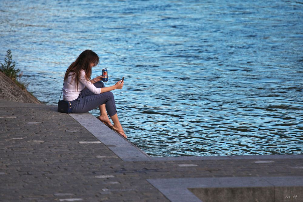 Mit Büchse Bier und Handy am Rhein