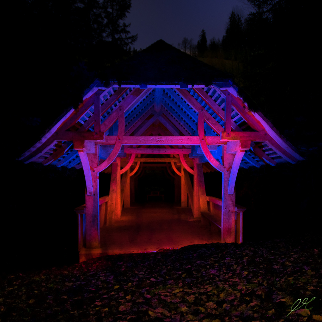 mit Licht bemalte Holzbrücke im Wald