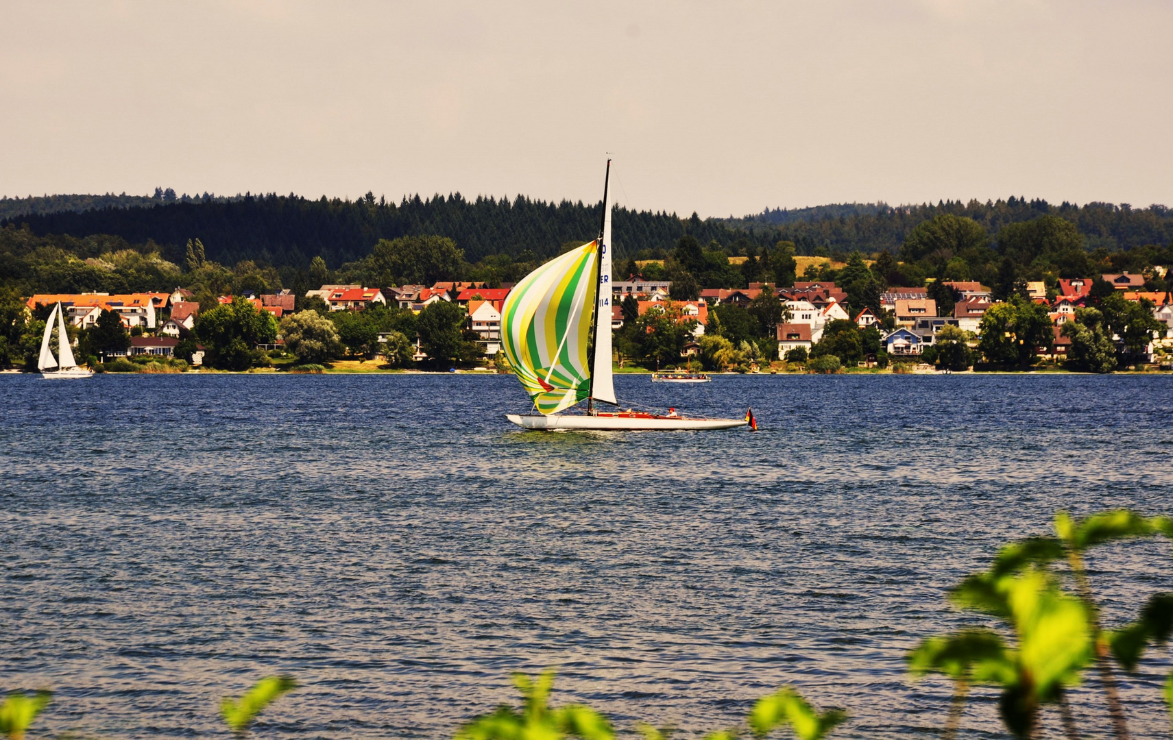 mit schönem pastell farbigem Segel übers Wasser