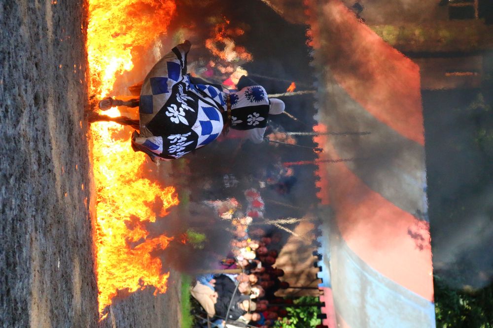 Mittelalterlicher Stuntreiter geht durch eine Feuerwand