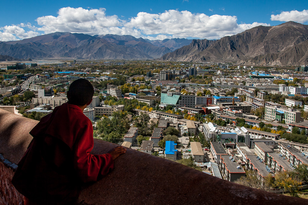 Mönch wirft ein Blick auf modernen Lhasa