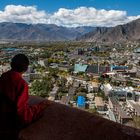Mönch wirft ein Blick auf modernen Lhasa