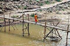 Moine traversant un pont suspendu