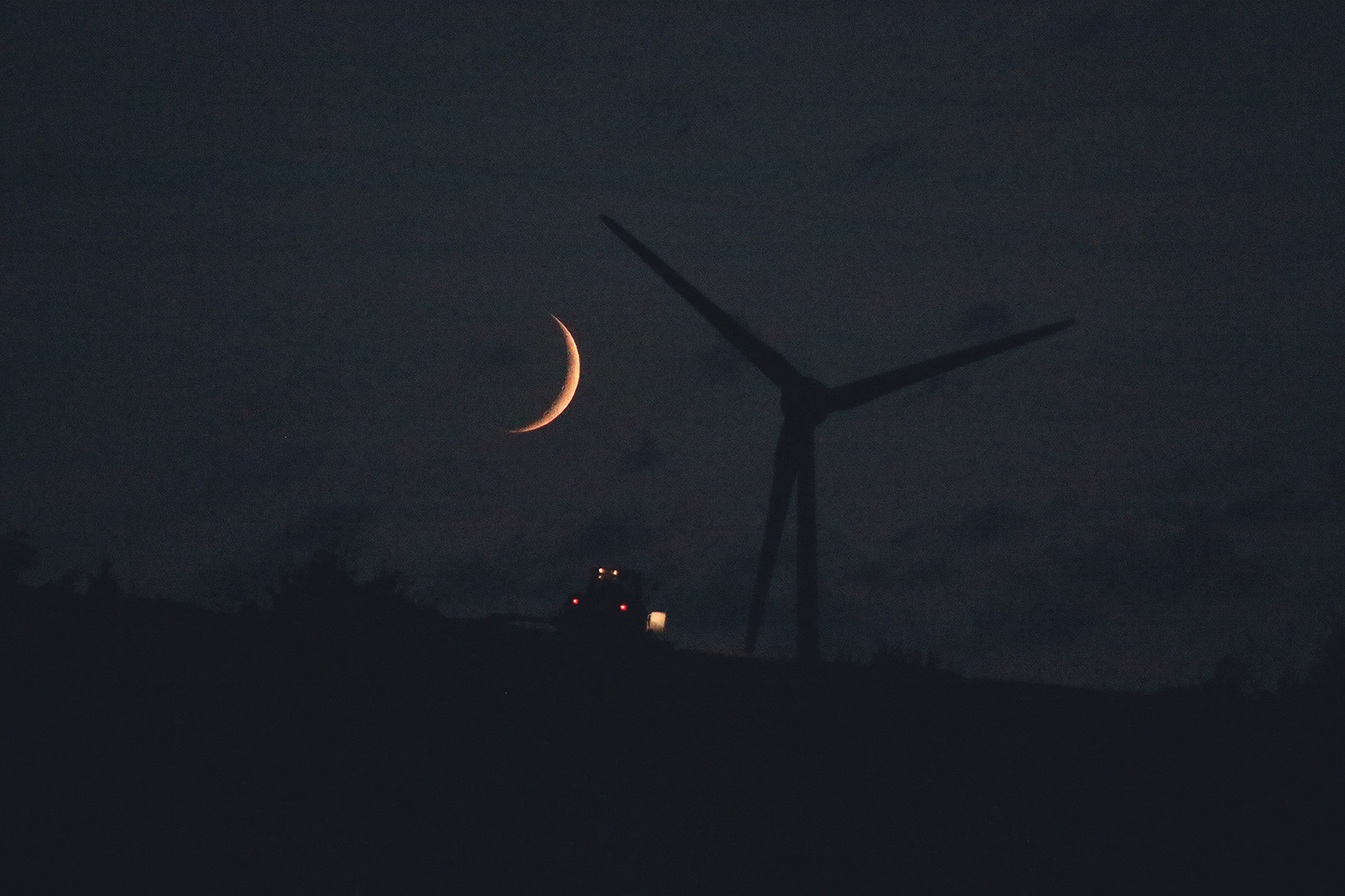 Mond an Windrad von Traktor durchschossen