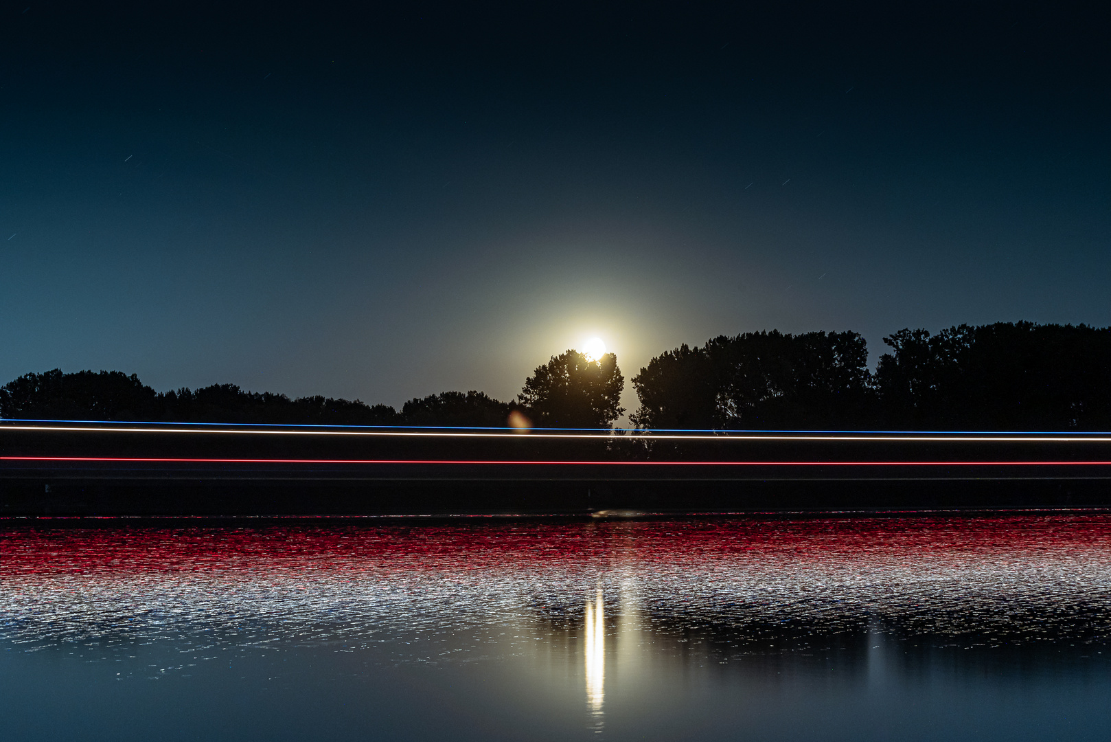 Mondaufgang am Rhein mit vorbeifahrendem Schiff