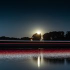 Mondaufgang am Rhein mit vorbeifahrendem Schiff