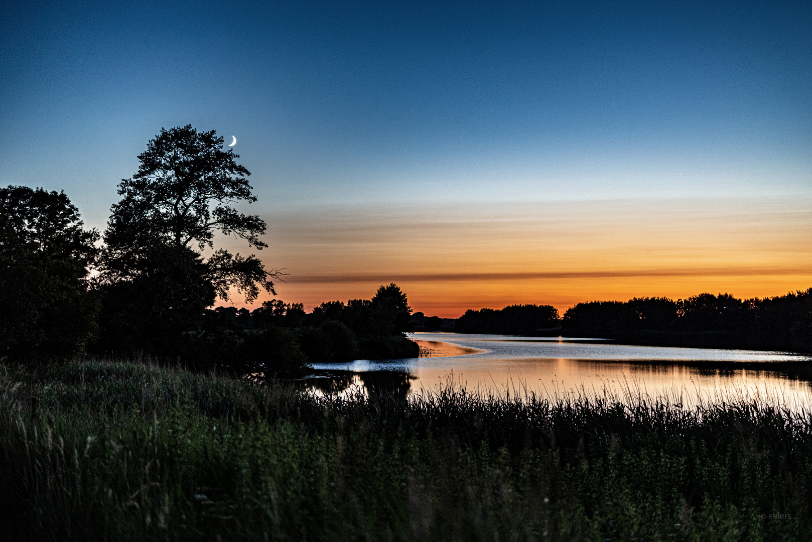 Mondaufgang und Sonnenuntergang über dem Wasser