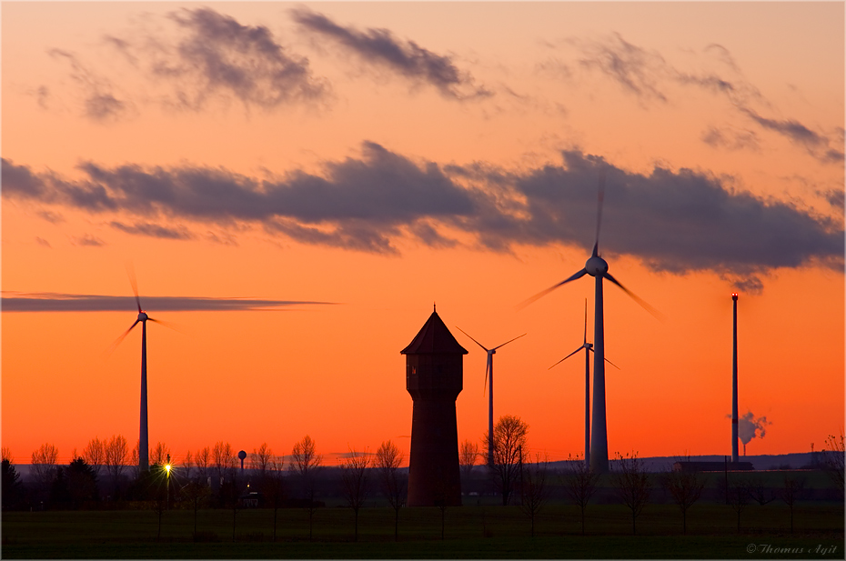 Montagabendrot an mittigem und nichtmittigem Wasserturm, einigen Windrädern und Kohlekraftwerk...