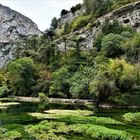 Montage vêtue au manteau vert les pieds dans l'eau