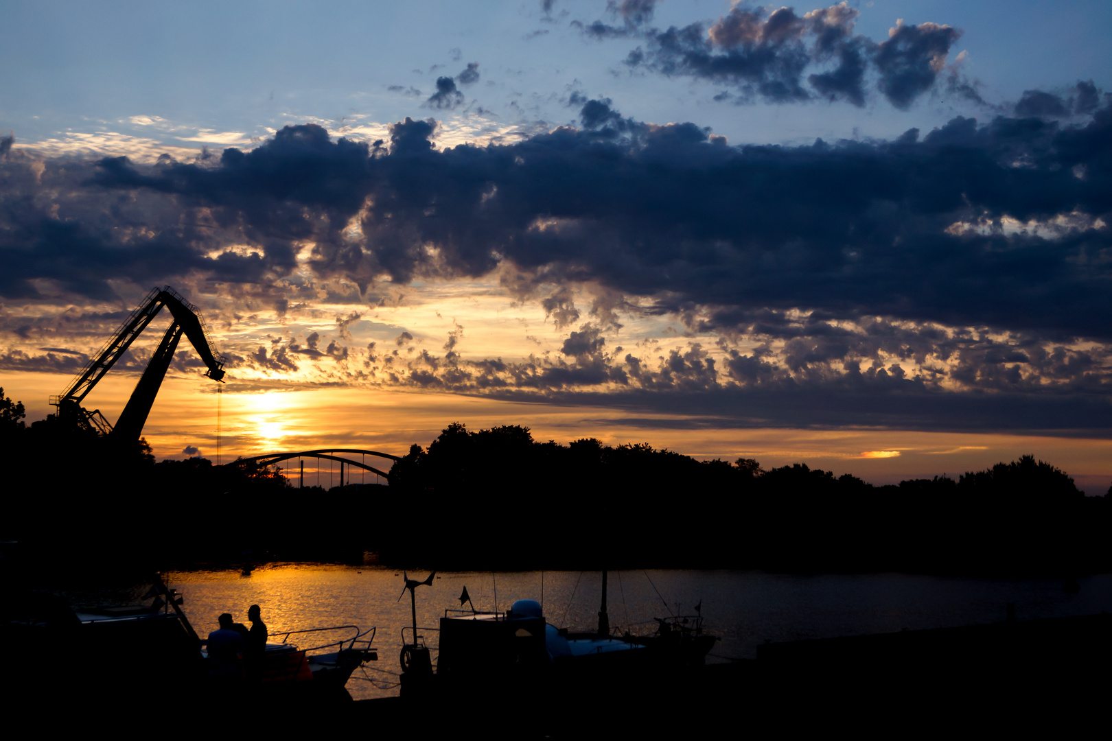 Moorkran mit Hafen bei Sonnenuntergang