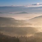 Morgennebel im Wasgau, mit Trifels im Hintergrund