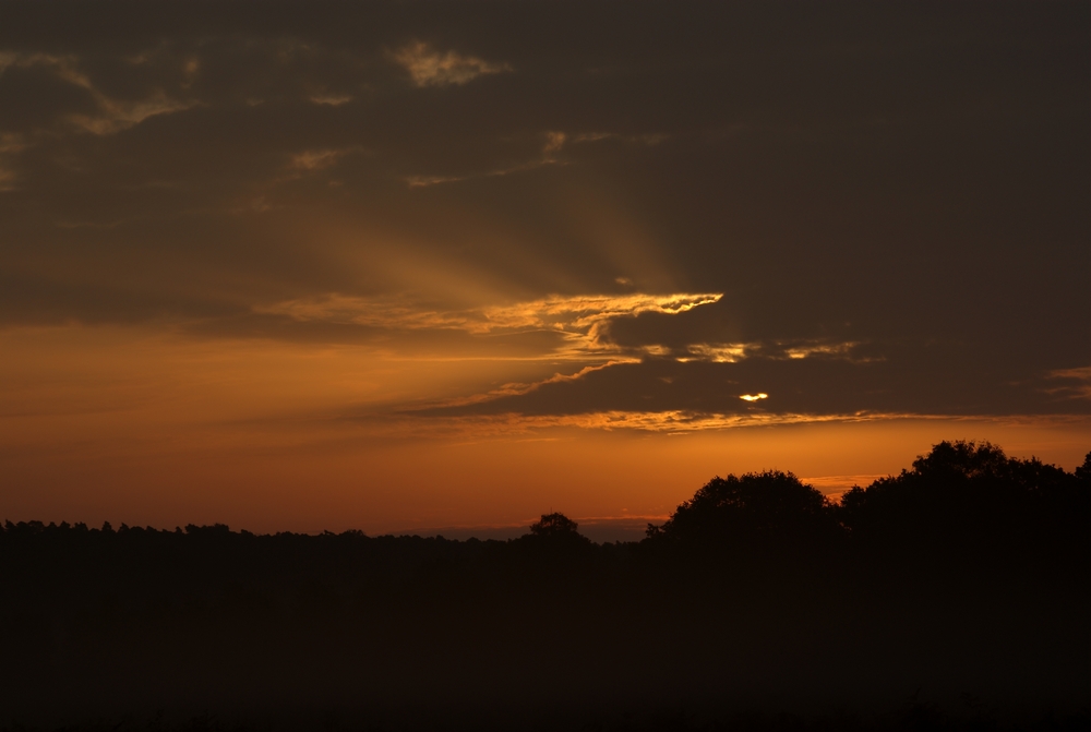 Morgensonne scheint durch die Wolken