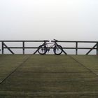 Mountainbike auf Steg im Nebel