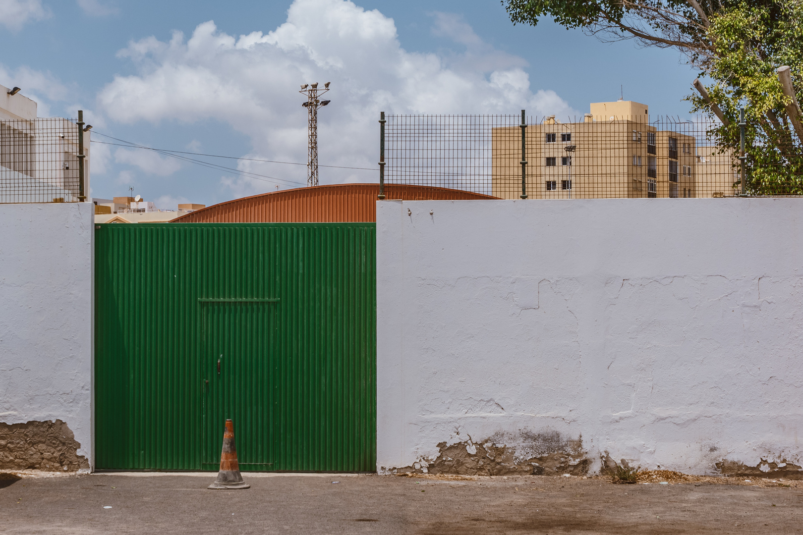 Muro bianco con cancello verde.