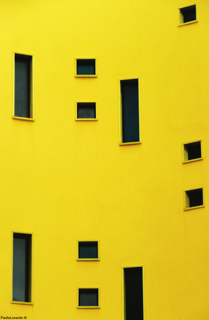 muro giallo con piccole finestre