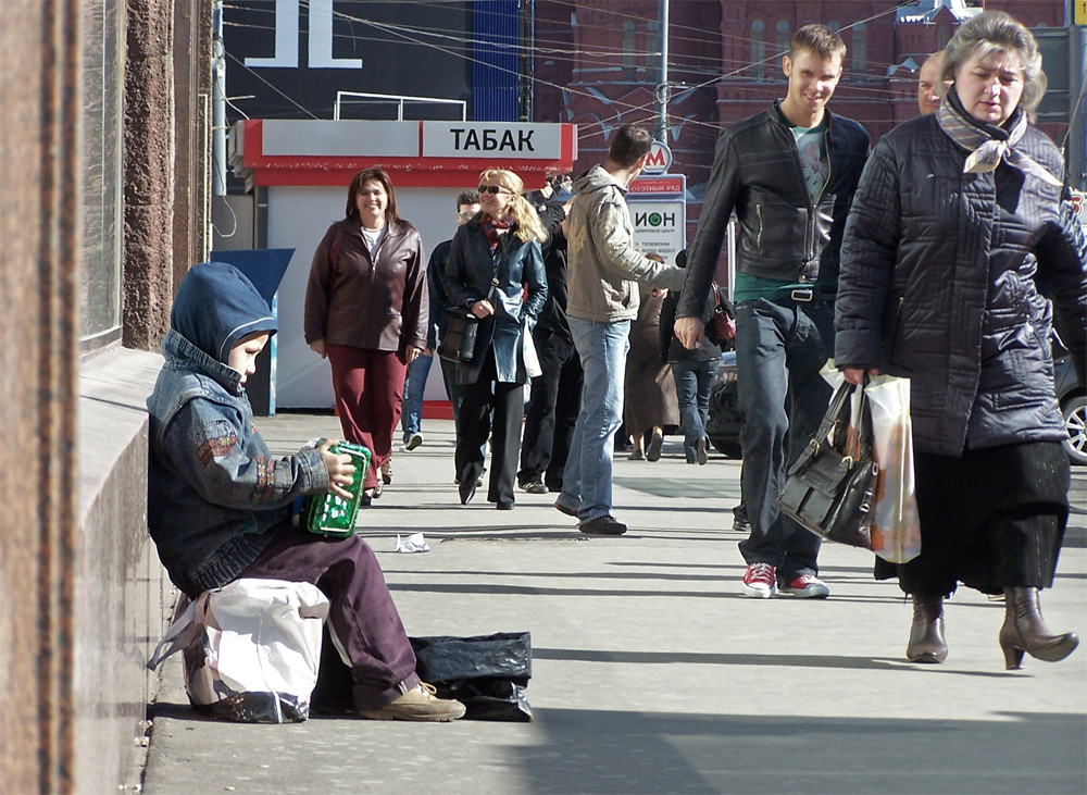 Musikantenjunge vor frontal kommenden Passanten vor Tabakladen und Metroeingang auf der Tverskaja