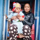 Mutter mit Kind vor ihrem Schmuckladen in Phaplu