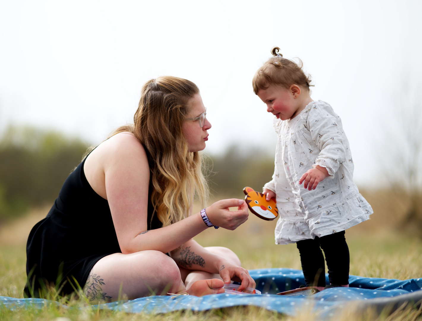 Mutter und Tochter schauen sich beim Picknick tief in die Augen