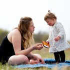 Mutter und Tochter schauen sich beim Picknick tief in die Augen