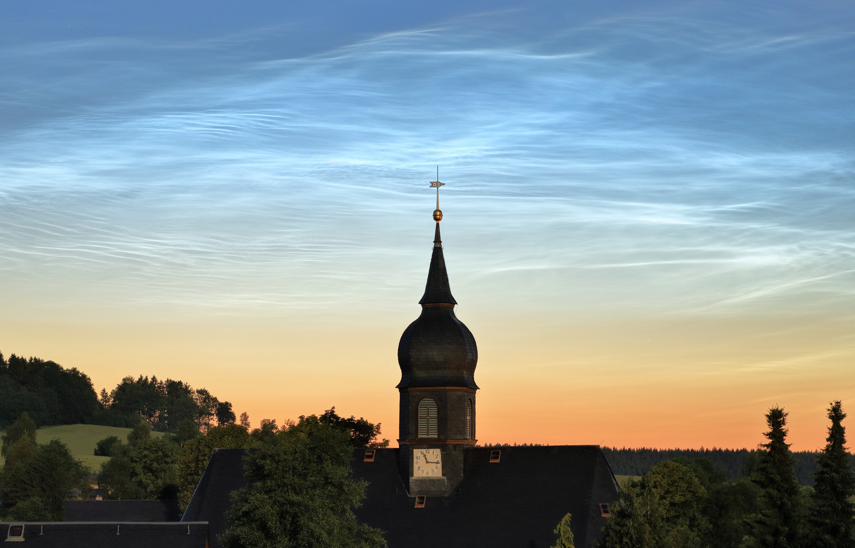 Nachtleuchtende Wolken über Schönbrunner Kirche