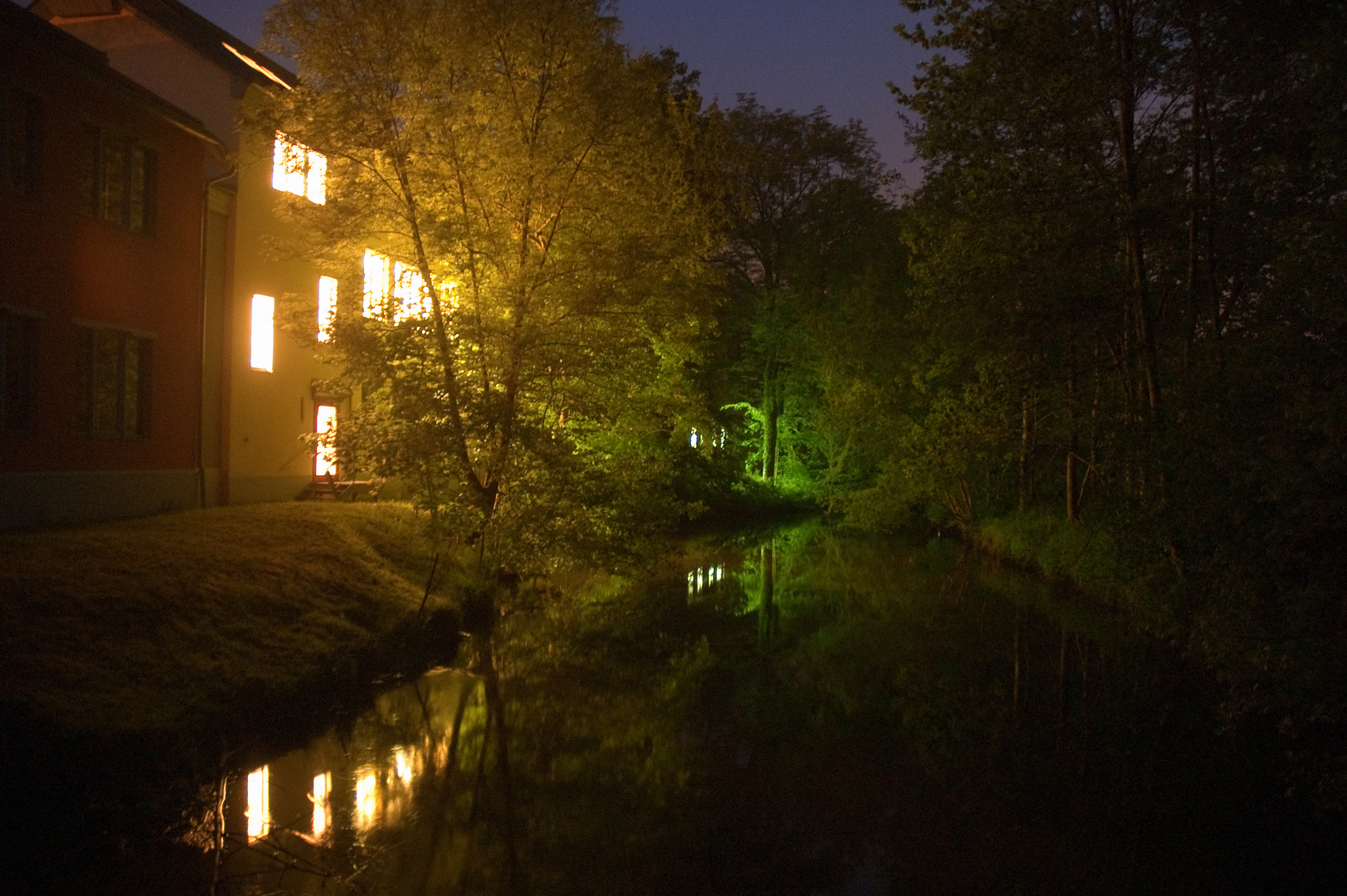 Nachts am beleuchteten Fluss