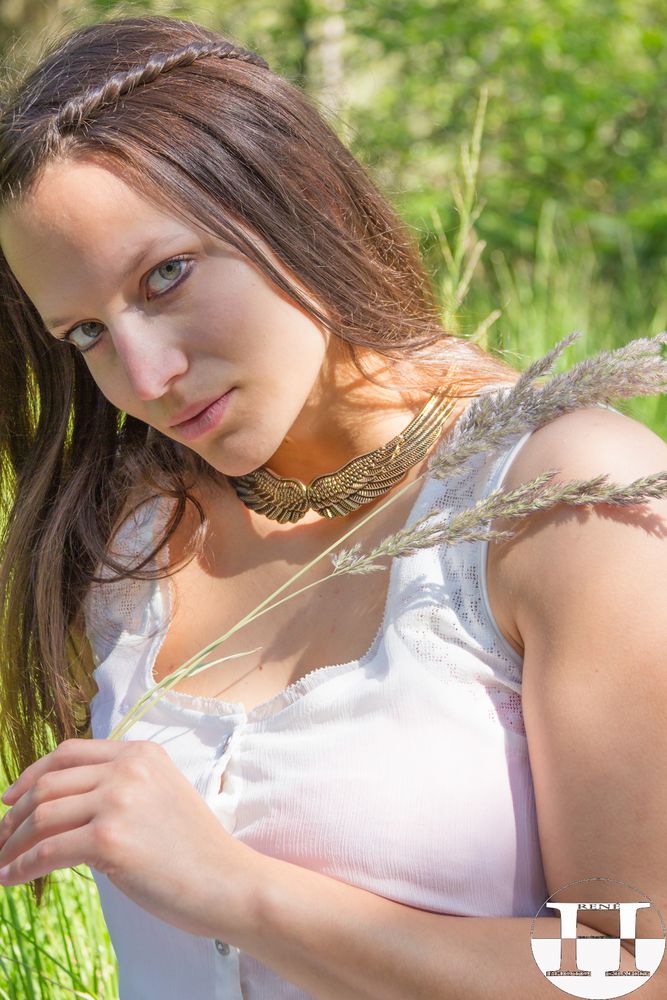 Natural Green Eyed Girl In White Dress With Feather Grass