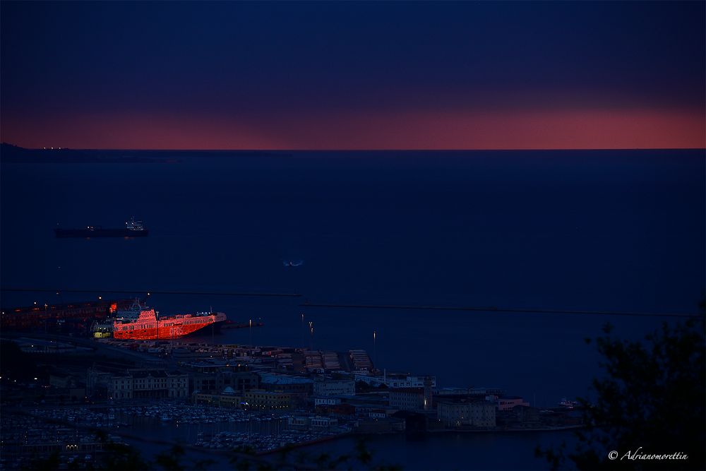 nave illuminata dal tramonto in porto a Trieste