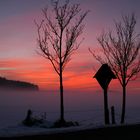 Nebel über Schneefeld mit Feldkreuz nach Sonnenuntergang