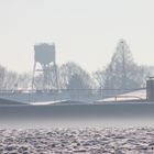 Nebel zieht bei strahlendem Sonnenschein über verschneite Felder