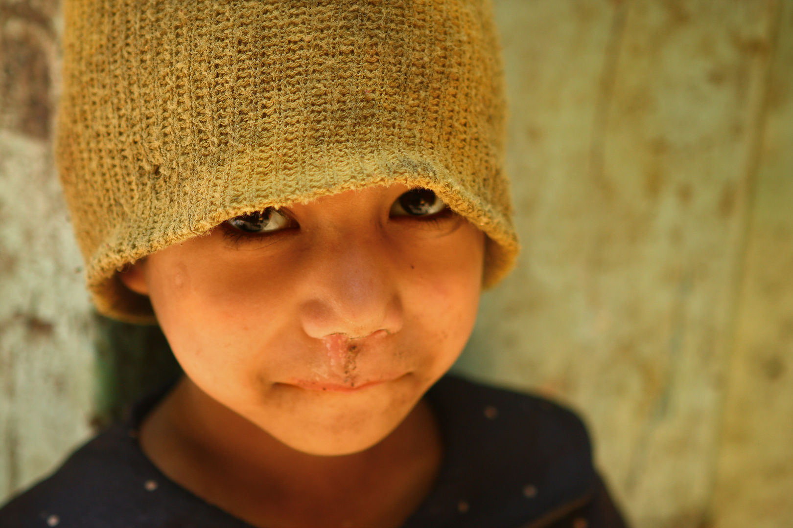 Nepali boy in a green hat.