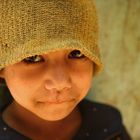 Nepali boy in a green hat.