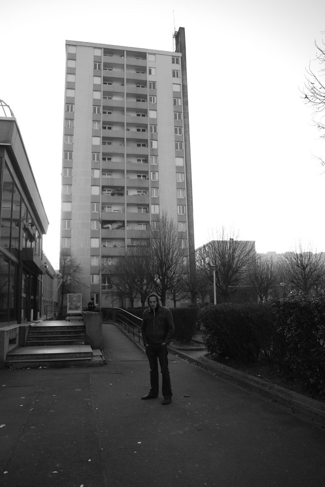 netter junger mann vor hochhaus in exqusiter lage