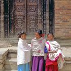 Newa girls in front of a carved gate in Bhaktapur