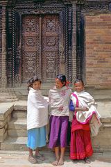 Newa girls in front of a carved gate in Bhaktapur