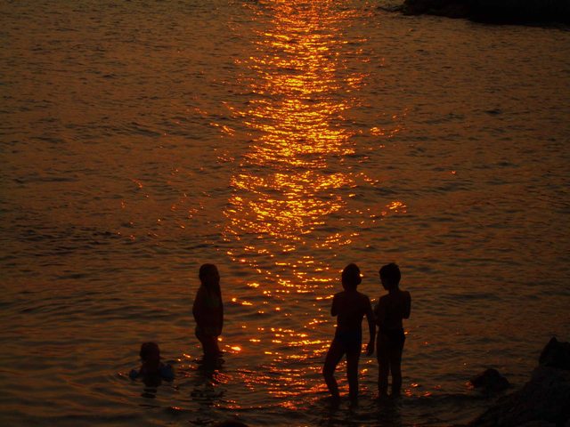 Niños bañandose al atardecer