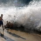 Niños jugando con las olas en verano en la playa de Zarautz